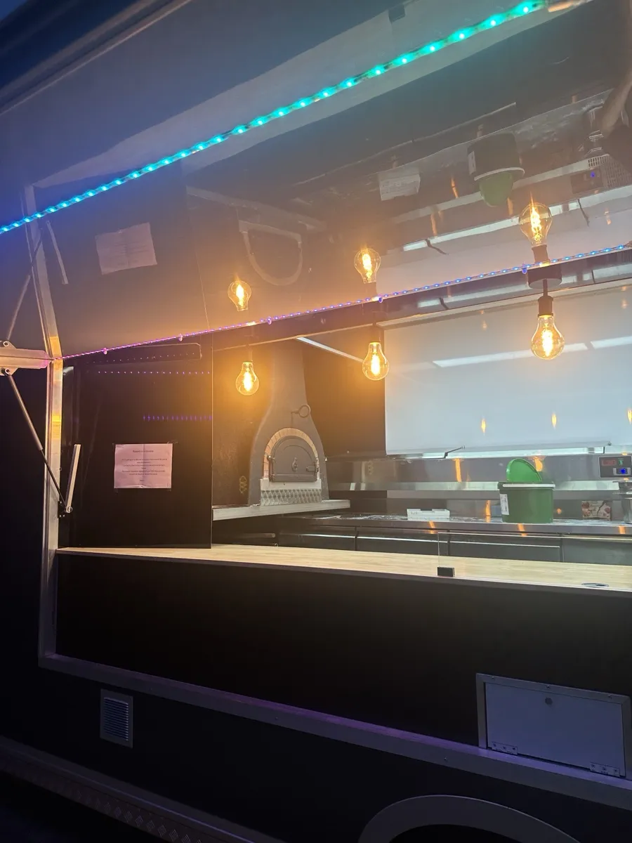 Le four à bois allumé, vu de l'intérieur du food truck Pizza Thaololo