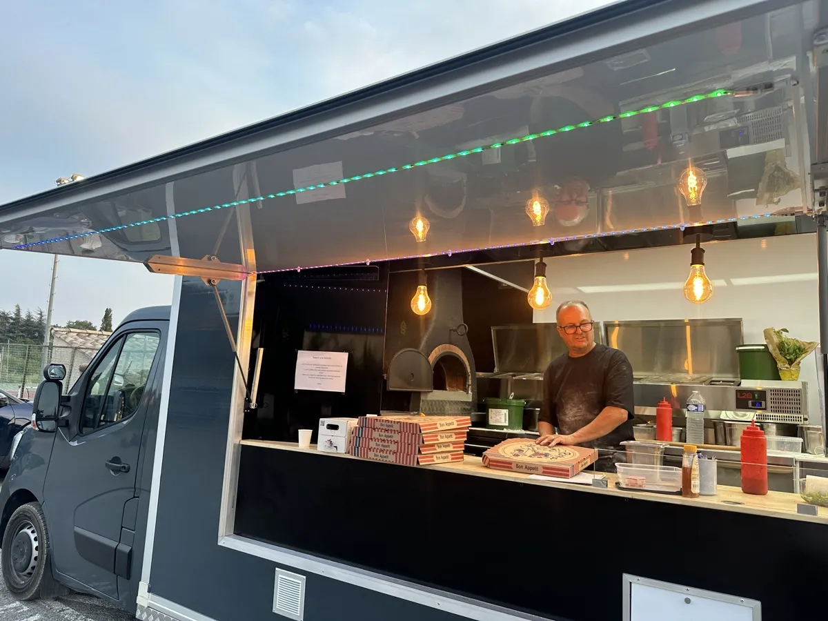 Comptoir du food truck Pizza Thaololo le soir, boîtes empilées