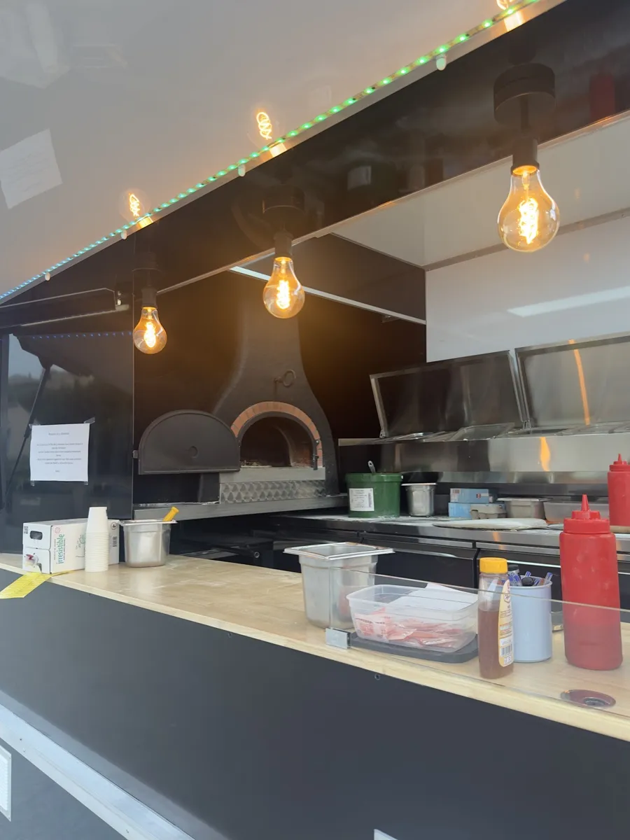 Intérieur du food truck Pizza Thaololo, ampoules et four allumés